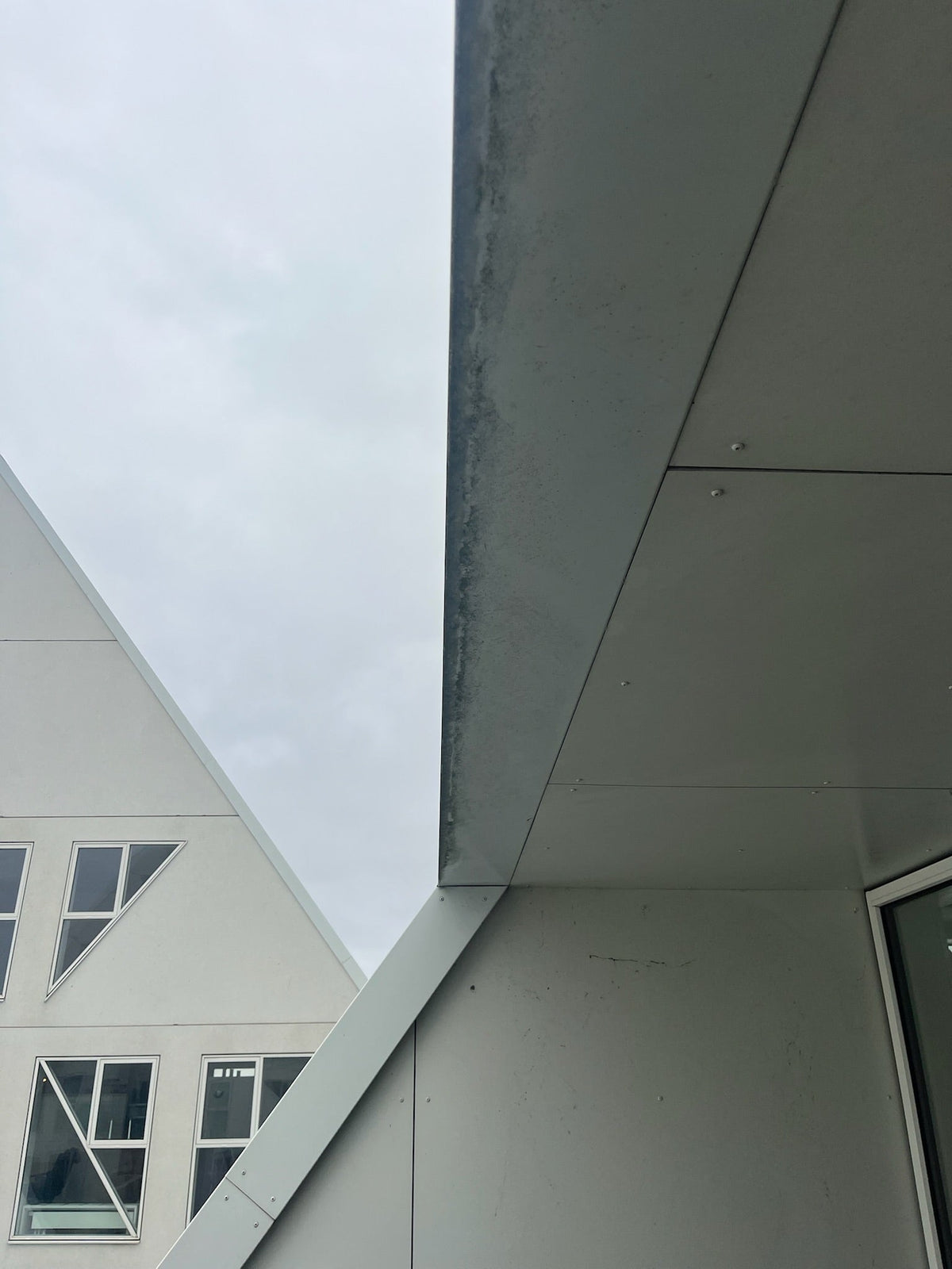 Renset facade på Isbjerget i Aarhus Ø efter professionel algebehandling og overfladevask udført af Øens HåndværkerCentral – tydeligt resultat med ren og ensartet overflade.
